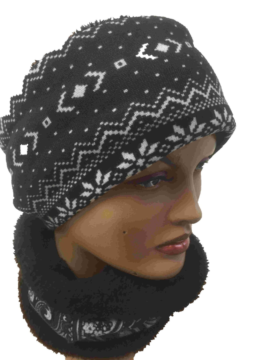 Mannequin wearing a black and white snowflake-pattern warmer pulled up as a hat and a dark faux-fur warmer around the neck
